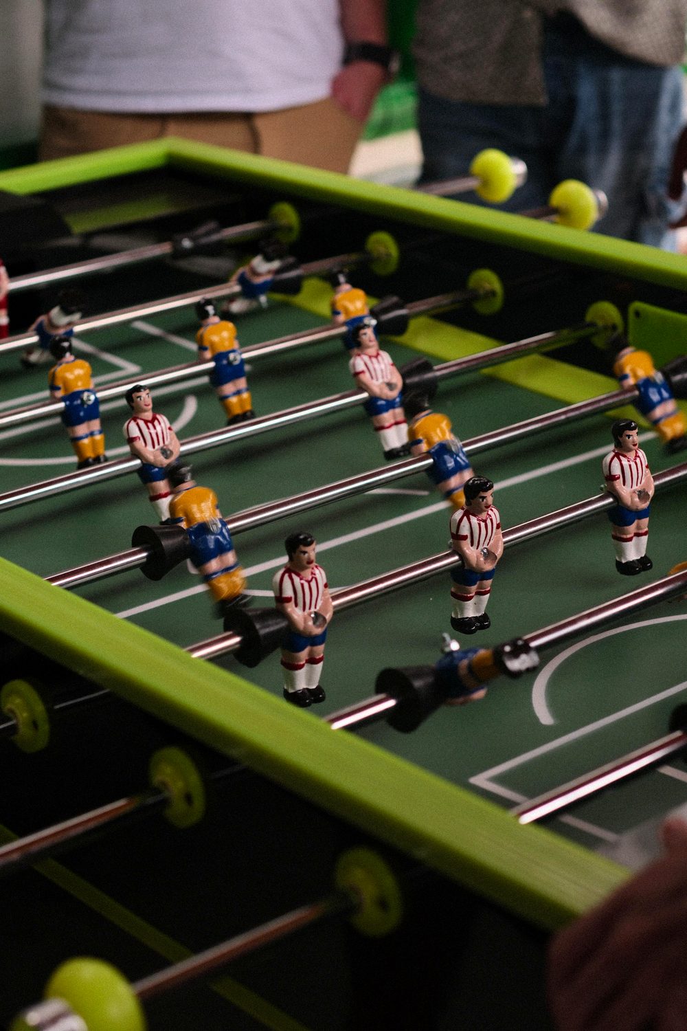Mesa de futbolito verde con los jugadores en primer plano