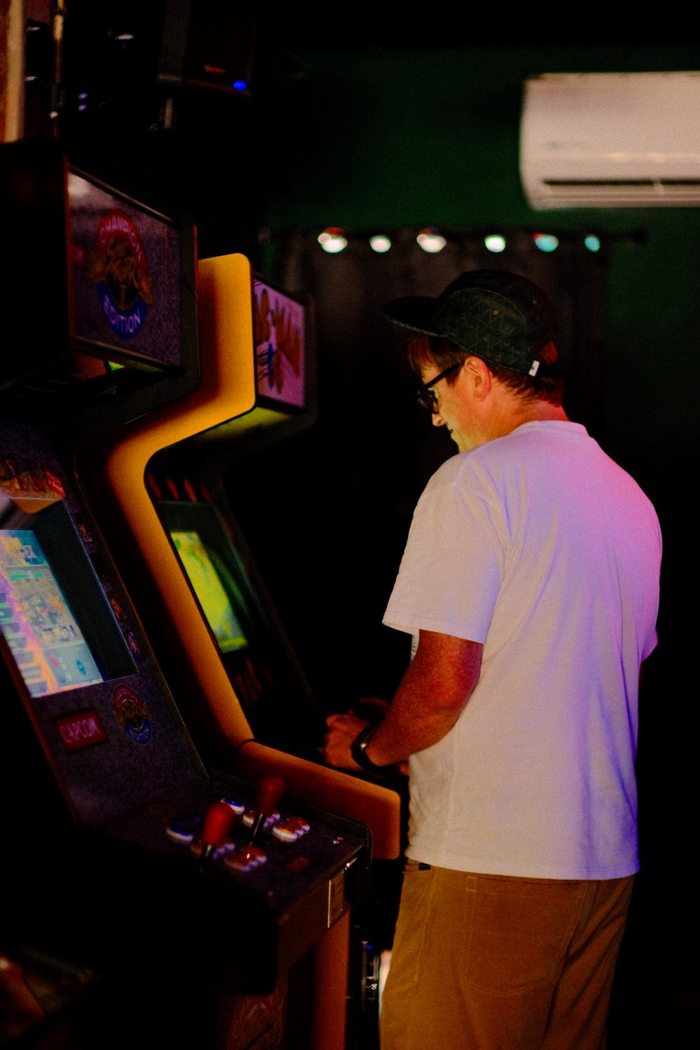 Una persona jugando en una de las máquinas arcade de pie del bar